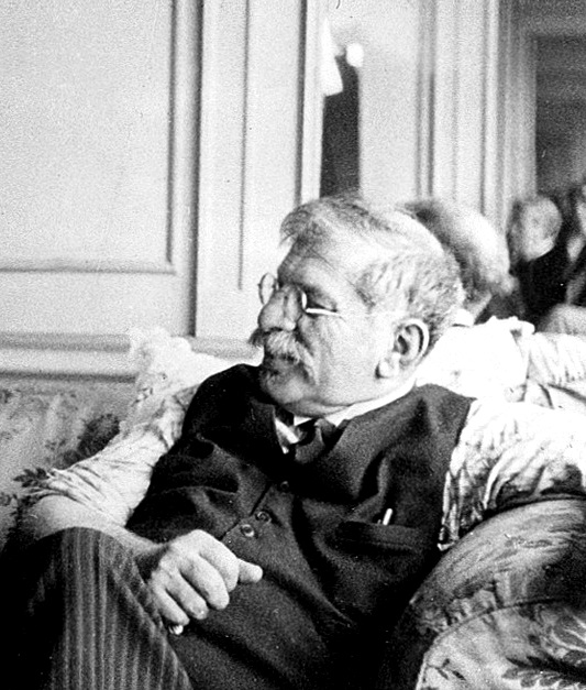 Dr. Magnus Hirschfeld relaxing on a couch with a smile on his face